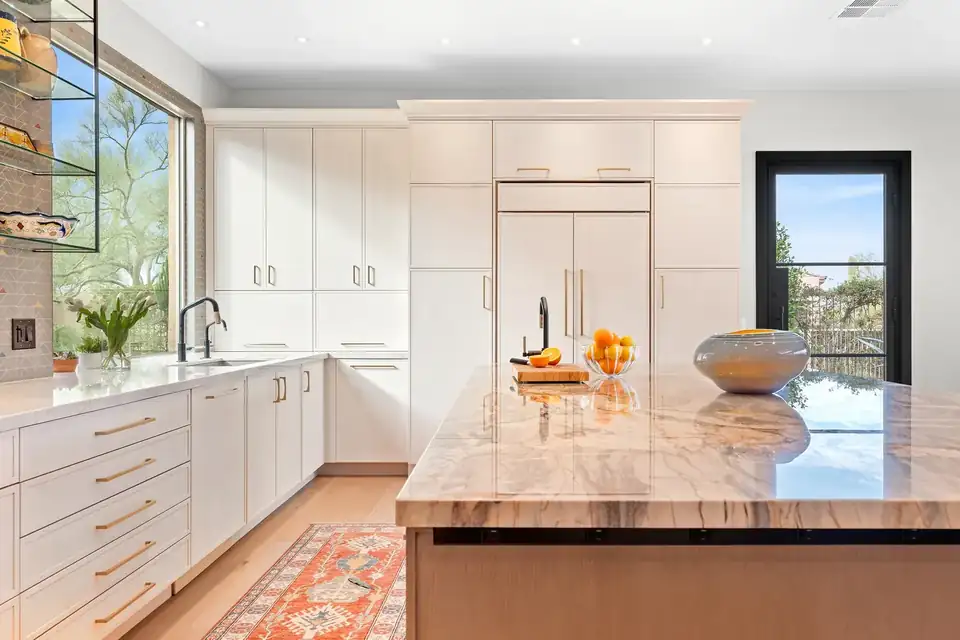 Kitchen remodeling Scottsdale AZ: Troon, North Scottsdale kitchen with white flat-panel cabinets, a paneled refrigerator, a veined stone island and a large picture window